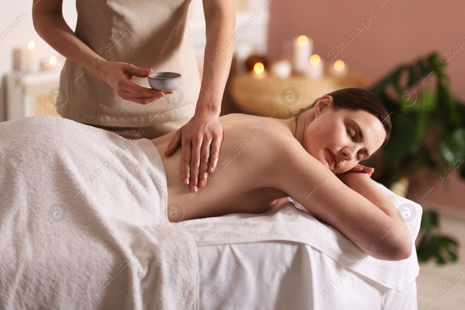 Woman receiving back massage with oil in spa salon Photo of Woman receiving back massage with oil in spa salon