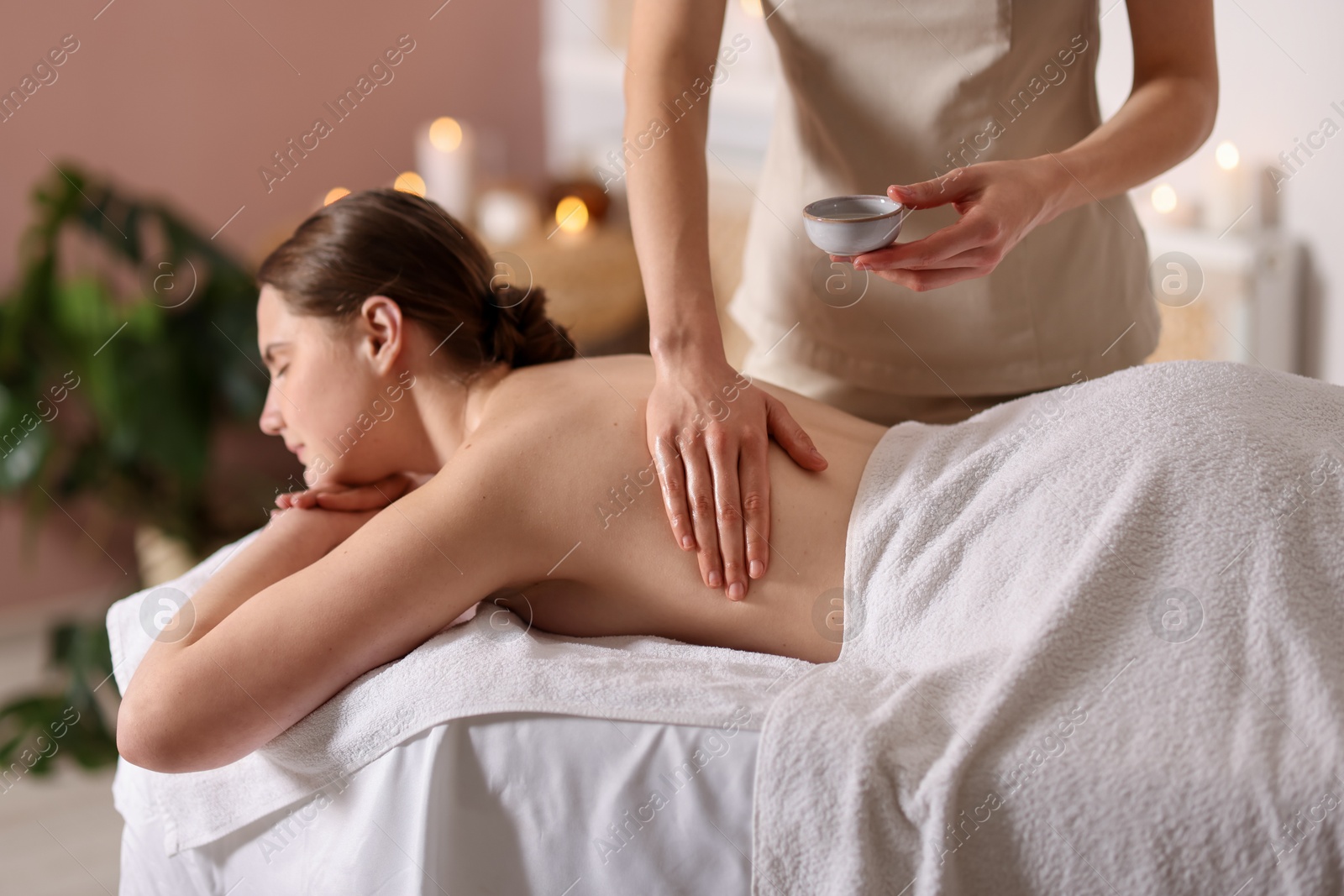 Woman receiving back massage with oil in spa salon Photo of Woman receiving back massage with oil in spa salon