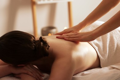 Photo of Woman receiving back massage with oil in spa salon