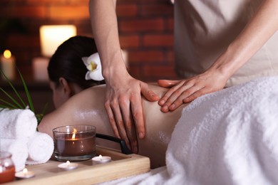 Photo of Woman receiving back massage with oil in spa salon