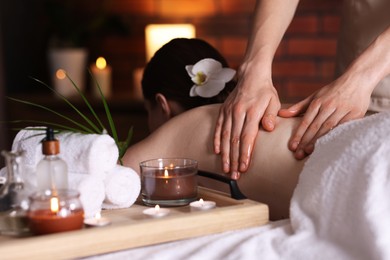 Photo of Woman receiving back massage with oil in spa salon