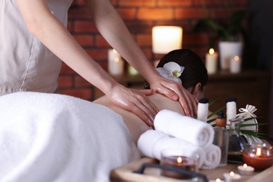 Photo of Woman receiving back massage with oil in spa salon