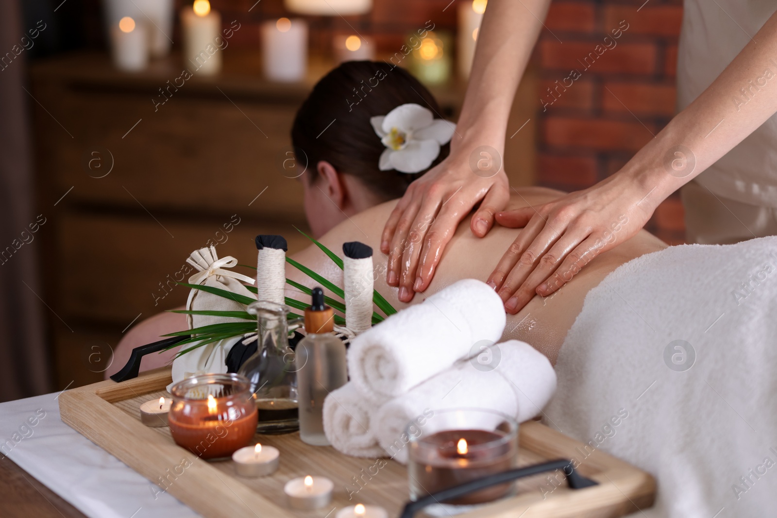 Woman receiving back massage with oil in spa salon Photo of Woman receiving back massage with oil in spa salon