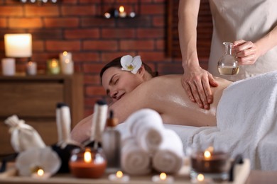 Photo of Woman receiving back massage with oil spa salon