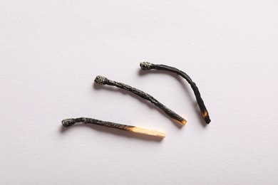 Photo of Burnt matches on light grey background, flat lay
