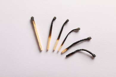 Photo of Burnt matches on light grey background, flat lay