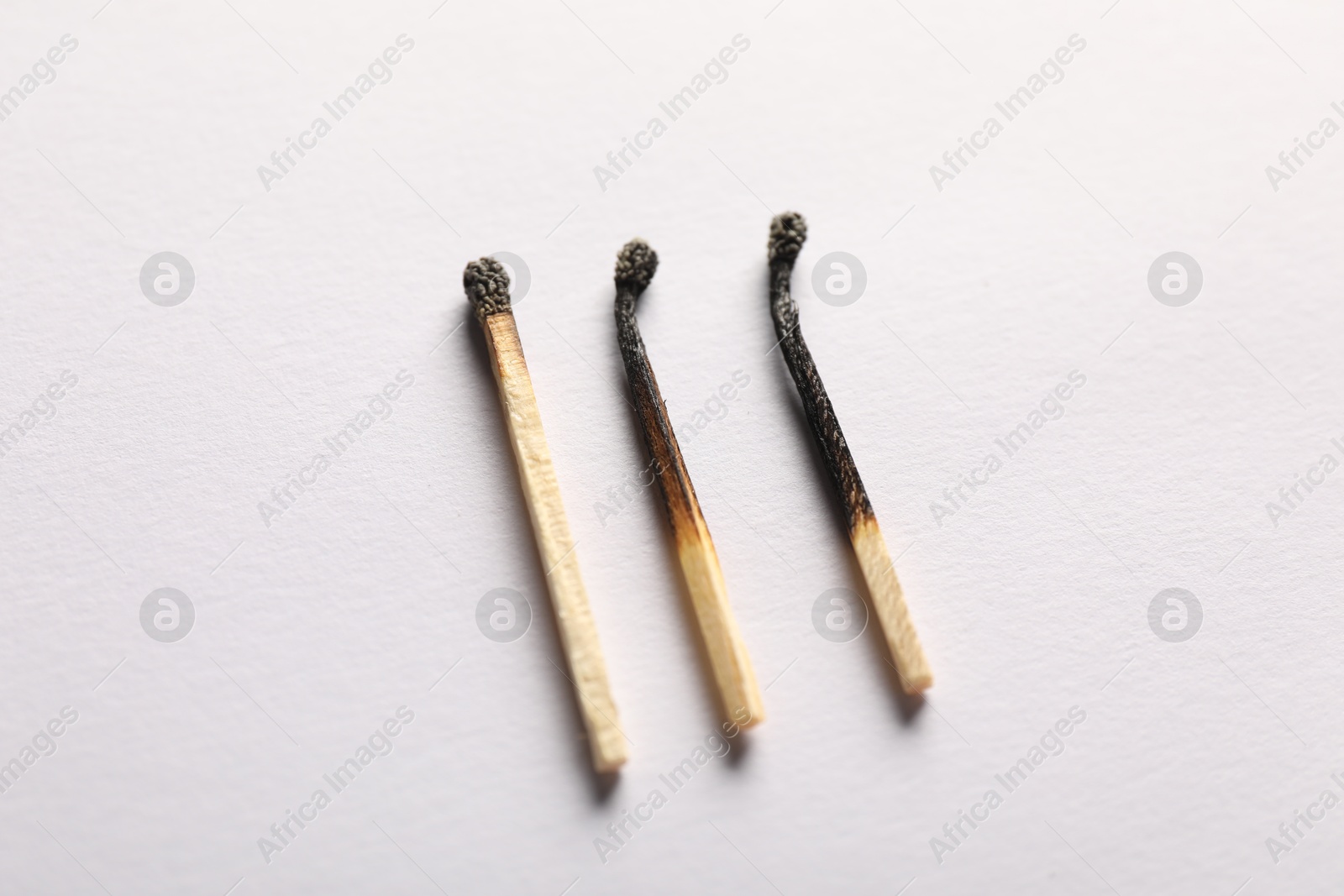 Burnt matches on light grey background, closeup Photo of Burnt matches on light grey background, closeup