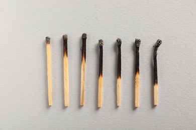 Photo of Burnt matches on grey background, flat lay