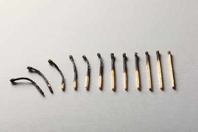 Photo of Burnt matches on grey background, above view