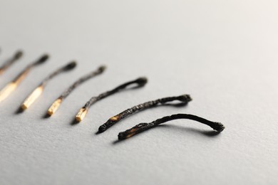 Photo of Burnt matches on grey background, closeup view