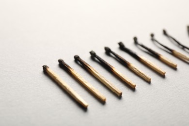 Photo of Burnt matches on grey background, closeup view