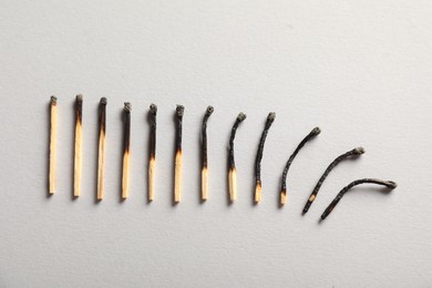 Photo of Burnt matches on grey background, flat lay