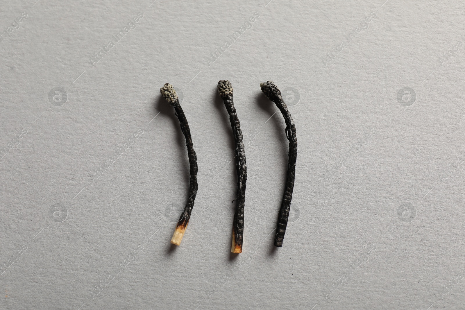 Burnt matches on grey background, flat lay Photo of Burnt matches on grey background, flat lay
