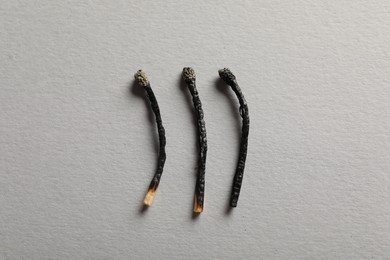 Photo of Burnt matches on grey background, flat lay