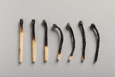 Photo of Burnt matches on grey background, flat lay