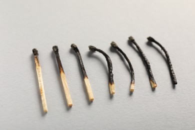 Photo of Burnt matches on grey background, closeup view