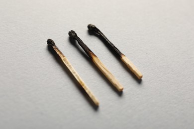 Photo of Burnt matches on grey background, closeup view