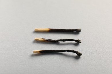 Photo of Burnt matches on grey background, closeup view