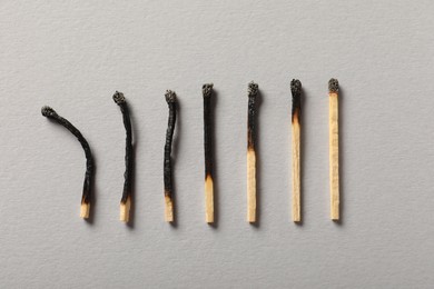 Photo of Burnt matches on grey background, flat lay