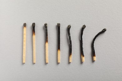Photo of Burnt matches on grey background, flat lay