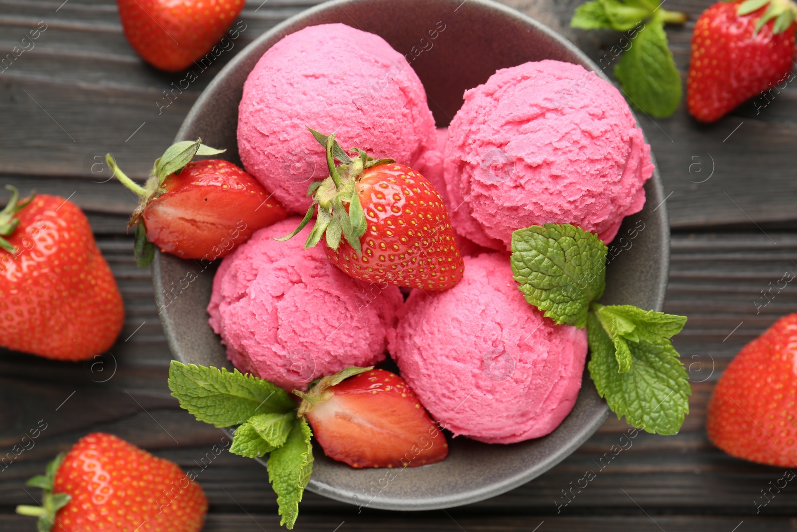 Photo of Tasty sorbet with strawberries and mint served on wooden table, flat lay