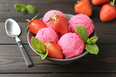 Photo of Tasty sorbet with strawberries and mint served on wooden table, closeup