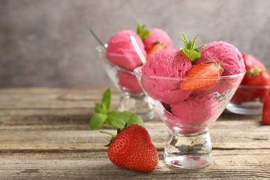 Photo of Tasty sorbet with strawberries and mint served on wooden table, closeup. Space for text