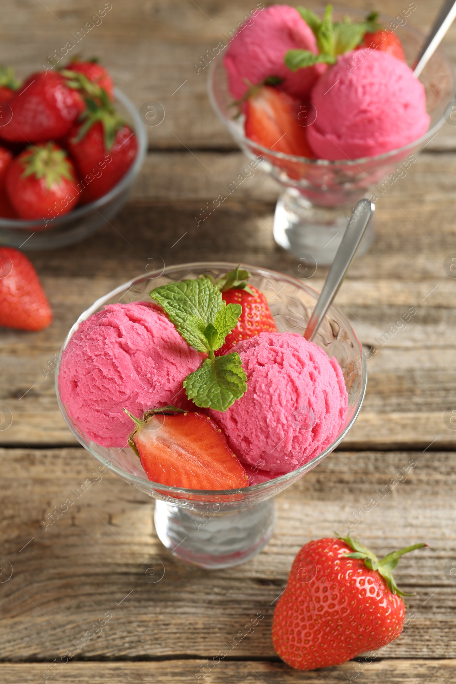 Tasty sorbet with strawberries and mint served on wooden table, closeup Photo of Tasty sorbet with strawberries and mint served on wooden table, closeup