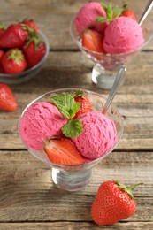 Photo of Tasty sorbet with strawberries and mint served on wooden table, closeup