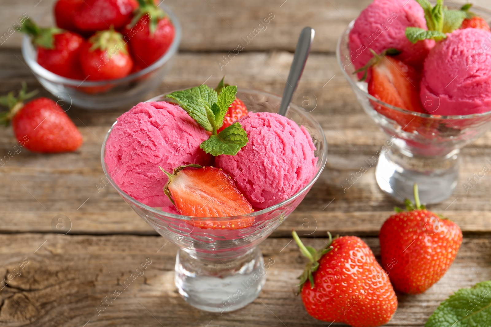 Tasty sorbet with strawberries and mint served on wooden table, closeup Photo of Tasty sorbet with strawberries and mint served on wooden table, closeup