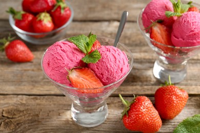 Photo of Tasty sorbet with strawberries and mint served on wooden table, closeup