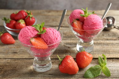 Photo of Tasty sorbet with strawberries and mint served on wooden table, closeup