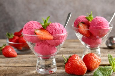 Photo of Tasty sorbet with strawberries and mint served on wooden table, closeup