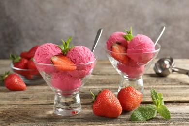 Photo of Tasty sorbet with strawberries and mint served on wooden table