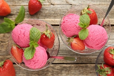 Photo of Tasty sorbet with strawberries and mint served on wooden table, flat lay