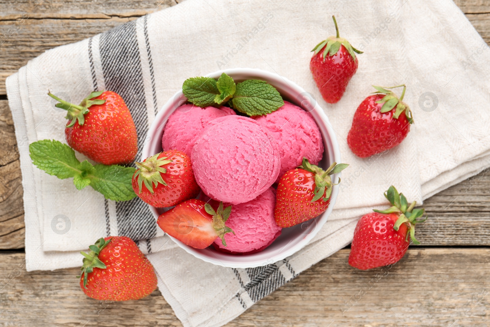 Photo of Tasty sorbet with strawberries and mint served on wooden table, flat lay