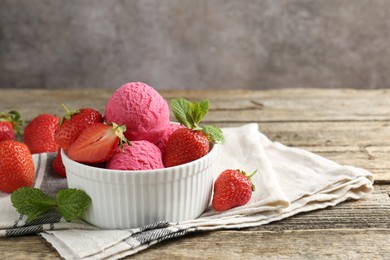 Photo of Tasty sorbet with strawberries and mint served on wooden table, closeup. Space for text