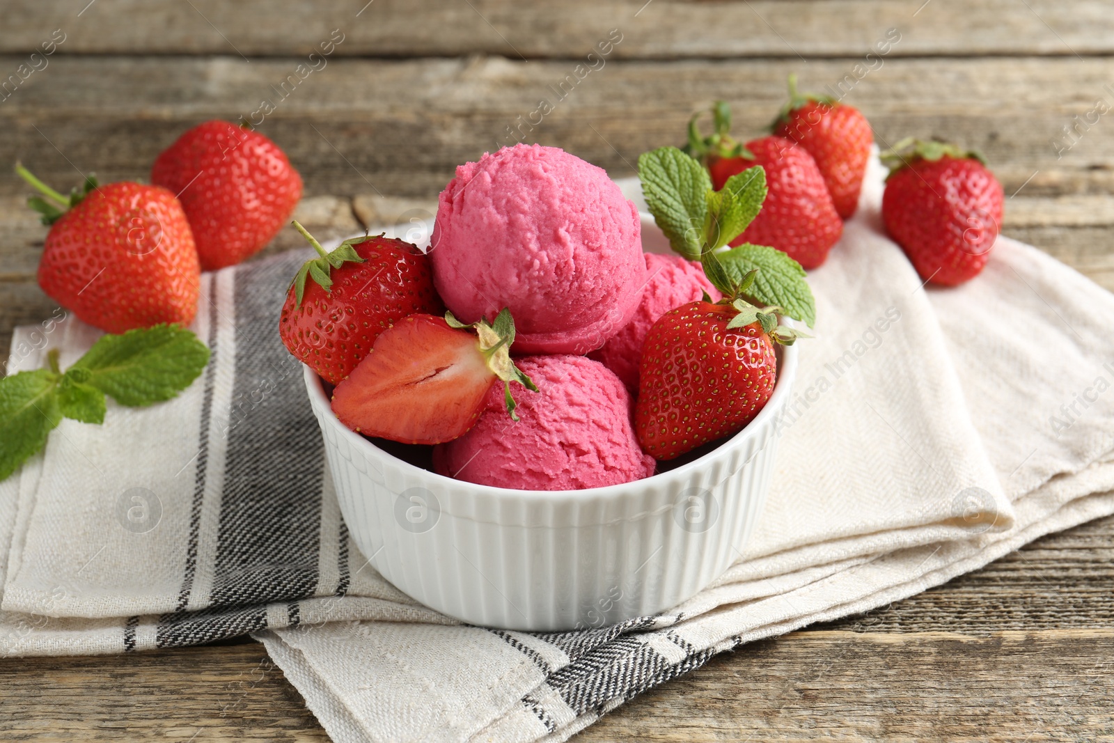 Photo of Tasty sorbet with strawberries and mint served on wooden table, closeup