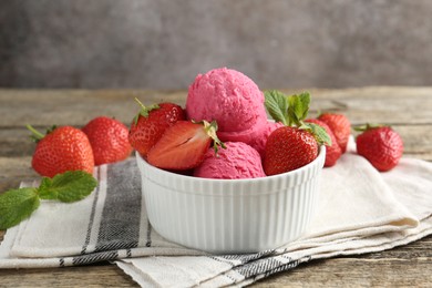 Photo of Tasty sorbet with strawberries and mint served on wooden table, closeup