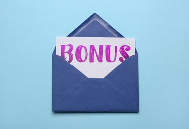 Image of Paper with word Bonus in envelope on light blue background, top view