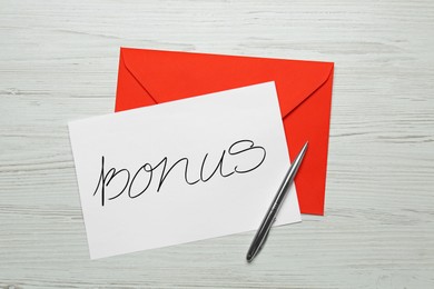 Image of Paper with word Bonus, pen and red envelope on white wooden table, top view