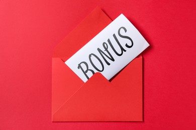 Image of Card with word Bonus in envelope on red background, top view