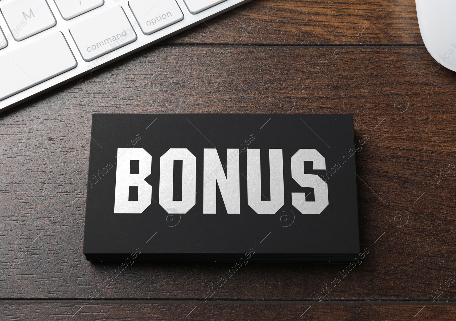 Black bonus card and computer keyboard on wooden table, top view Image of Black bonus card and computer keyboard on wooden table, top view