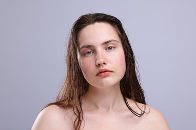 Photo of Portrait of woman with natural skin complexion on grey background, closeup