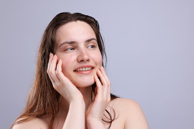 Photo of Smiling woman with natural skin complexion on grey background, closeup. Space for text