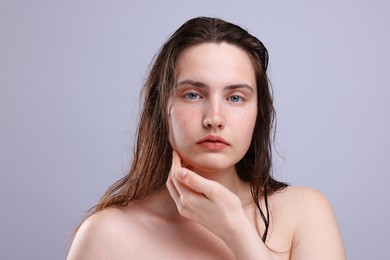 Photo of Portrait of woman with natural skin complexion on grey background, closeup