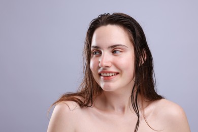 Photo of Smiling woman with natural skin complexion on grey background, closeup. Space for text