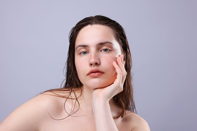 Photo of Portrait of woman with natural skin complexion on grey background, closeup
