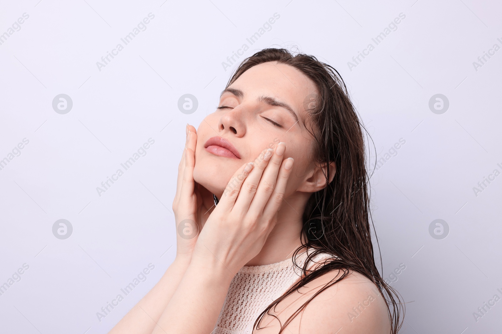 Beautiful woman with natural skin complexion on light grey background, closeup Photo of Beautiful woman with natural skin complexion on light grey background, closeup