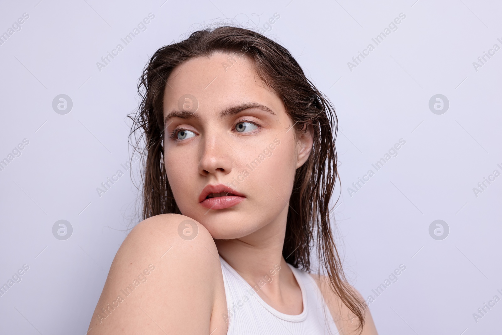 Beautiful woman with natural skin complexion on light grey background, closeup Photo of Beautiful woman with natural skin complexion on light grey background, closeup